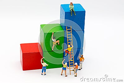 Miniature people : Group Athletes use stairs to climb colorful wood building. Image use for Activities, travel, business concept Stock Photo