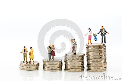 Miniature people: Group couple figure sitting on top of stack coins. Image use for retirement planning, Life insurance concept Stock Photo