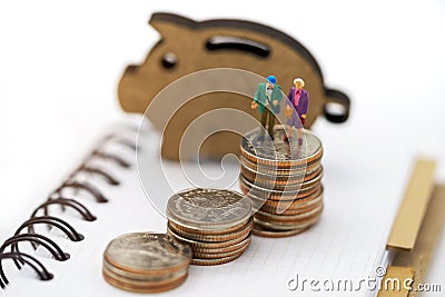 Miniature people: Happy old people standing on coins stack, Retirement planning, Emergency plan, Life insurance and Financial Stock Photo