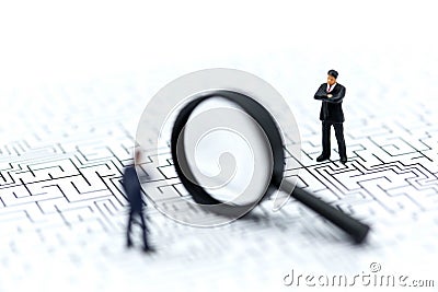 Miniature people: Magnifying glass focusing on the selected of b Stock Photo