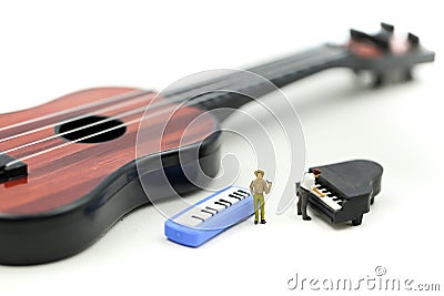 Miniature people : man play mini piano with sitting on acoustic guitar. time of relax or music relax concept Stock Photo