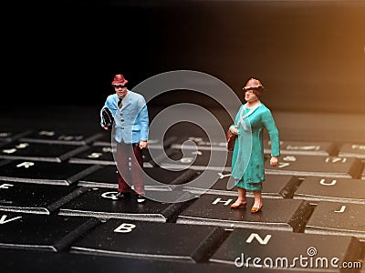 Miniature people man and woman carrying bags Stock Photo