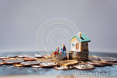 Miniature people, man and woman sitting on stack coins using as business and life success concept Stock Photo