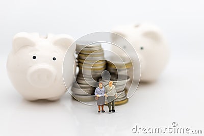 Miniature people, Old couple figure sitting on top of stack coins using as background retirement planning, Life insurance concept. Stock Photo