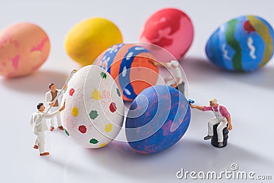 Miniature people painting easter eggs Stock Photo