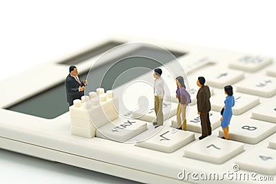 Miniature people Pay queue Annual income TAX for the year on calculator. using as background business concept and finance concep Stock Photo