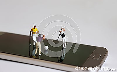 Miniature people playing golf on smart phones. The concept of online sports betting. Stock Photo