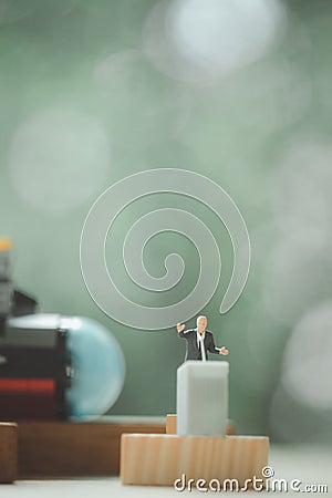 Miniature people of a politician stand on podium with submarine Stock Photo