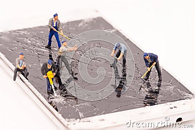 Miniature people repair smartphone crack Stock Photo