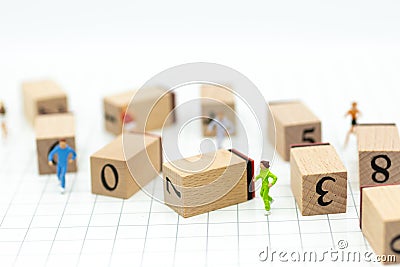 Miniature people running to stack of number wooden block . Image use for healthy , exercise concept Stock Photo