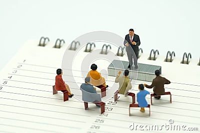 Miniature people sitting on red staples placed on a Book Rankings list. meeting or Discussion using as background business conce Stock Photo