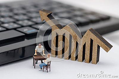Miniature people sitting on table with keyboard and wooden graph Stock Photo