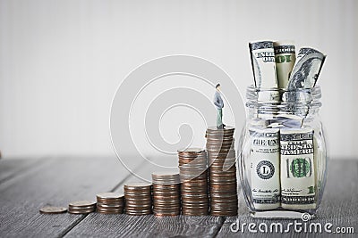 Miniature people small figure stand on coin money stack step up growing growth saving money with one hundred dollars Stock Photo