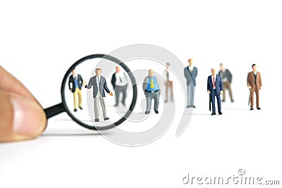 Miniature people toy figure photography. A shrugging businessman finding candidate standing in front of magnifier glass. Isolated Stock Photo