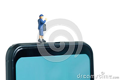 Miniature people toys conceptual photography. Mobile post service delivery. Postman courier standing above smartphone, isolated on Stock Photo