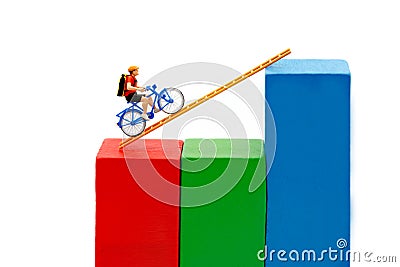 Miniature people: Traveler riding bicycle on wood ladder with gr Stock Photo