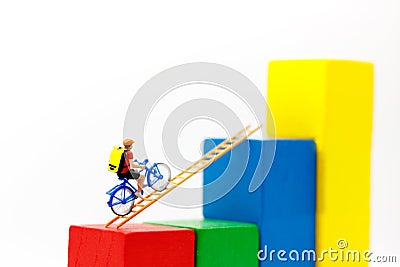 Miniature people: Traveler riding bicycle on wood ladder Stock Photo