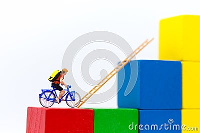 Miniature people : Traveler use the bicycle with takes the ladder from one place to another. Image use for travel, business concep Stock Photo