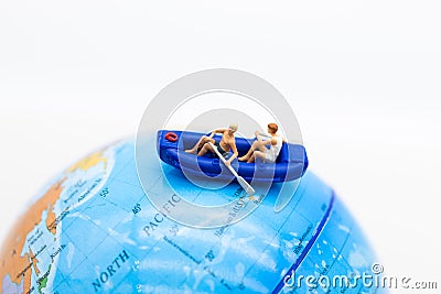 Miniature people : Travelers with paddle boat on world map. Image use for activities, travel business concept Stock Photo