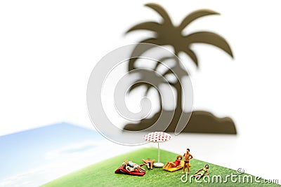 Miniature people wearing swimsuit relaxing on book and world map Stock Photo