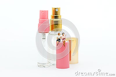 Miniature people: Women sit on perfume spray. Image use for cosmetic, beautiful concept Stock Photo