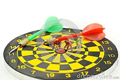 Miniature people : worker digging on the target on dart board, c Stock Photo