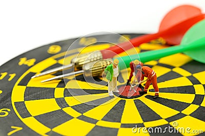 Miniature people : worker digging on the target on dart board, c Stock Photo