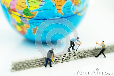 Miniature people: Worker fix the wall before the world. Concepts of finding a solution, problem solving and challenge Stock Photo