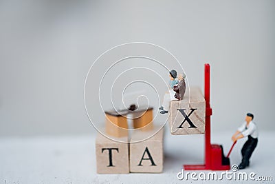 Miniature people worker wood word with TAX by forklift Stock Photo