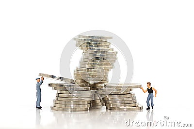 Miniature people : Workers work hard to keep money for everyday use. Stock Photo