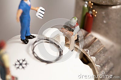 Miniature Plumbers Repairing A Thermostat Stock Photo