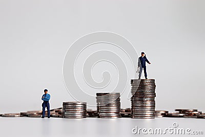 Miniature police holding loudspeakers on a pile of coins and miniature police standing next to a pile of coins. Stock Photo