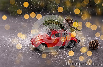 A miniature red car carries a Christmas tree on the roof Stock Photo