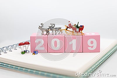 Miniature Santa Claus drive a wagon with a reindeer during the snowfall. Using as concept in Christmas day. Stock Photo