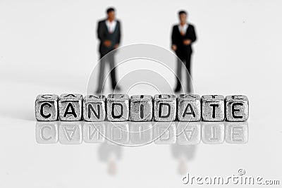 Miniature scale model politicians standing behind the word candidate Stock Photo