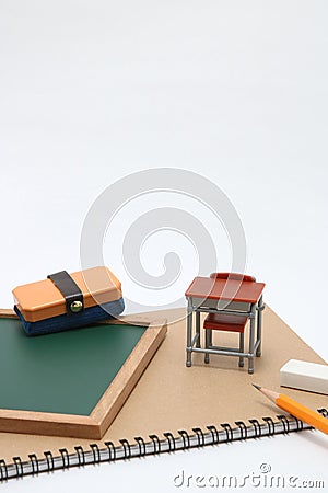 Miniature school desk, chalkboard and notebook on white background. Stock Photo