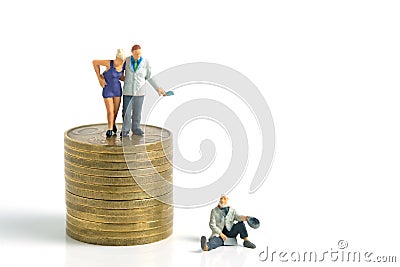 Miniature tiny people toys photography. a generous man standing on a pile of coins, giving money cash to a beggar poor man, Stock Photo