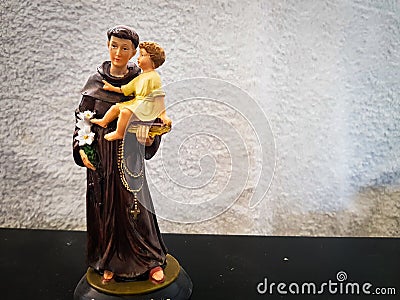 Toy figure of saint Anthony holding a boy child Stock Photo