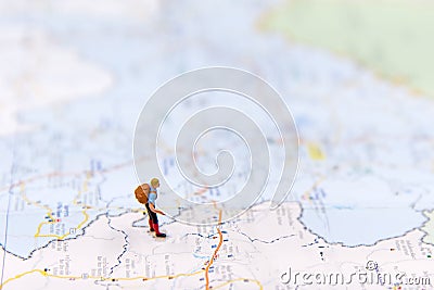 Miniature traveler with backpack standing on wold map for travel around the world. Stock Photo