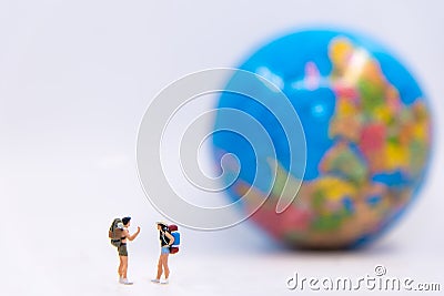 Miniature traveler and hiker backpack standing see the globe for the tourist and adventure around the world. Stock Photo