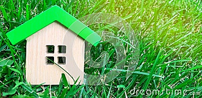 Miniature wooden house on grass. Real estate concept. Eco-friendly and energy efficient house. Buying a home outside the city. The Stock Photo