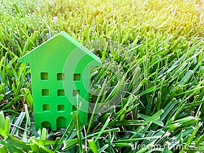 Miniature wooden house on grass. Real estate concept. Eco-friendly and energy efficient house. Buying a home outside the city. The Stock Photo