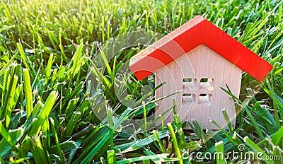 Miniature wooden house on grass. Real estate concept. Eco-friendly and energy efficient house. Buying a home outside the city. The Stock Photo