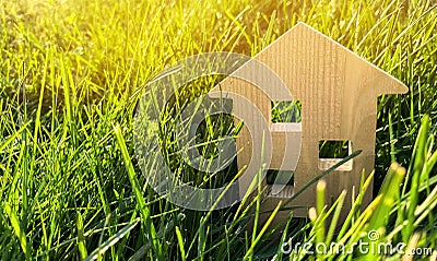 Miniature wooden house on green grass. Real estate concept. Modern housing. Eco-friendly and energy efficient house. Buying a home Stock Photo