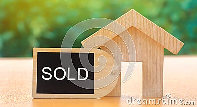 A miniature wooden house and inscription Sold. The concept of selling a home or apartment. Property for sale. Affordable housing. Stock Photo