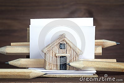 Miniature wooden house model, sketchbook and pencils Stock Photo