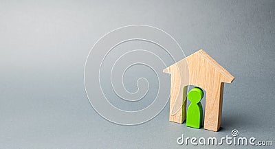 Miniature wooden house with a tenant inside. The concept of renting a house or apartment. Affordable housing. Mortgage. Home loan Stock Photo