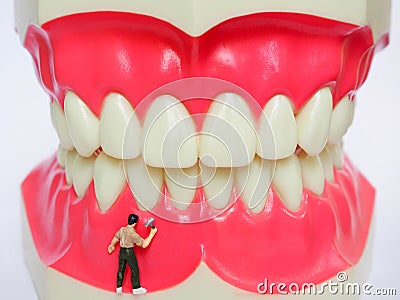 Miniature worker on plastic teeth of removable denture. Dental h Stock Photo