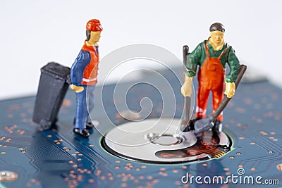 Miniature Workers cleaning a broken hard drive and recycle it Stock Photo