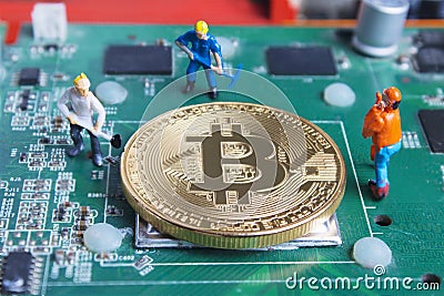 Miniature working man digging and mining Bitcoin on printed circuit board Stock Photo